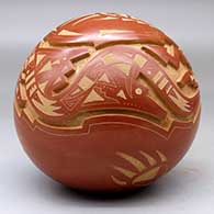 A red and micaceous golden seed pot carved with an avanyu, bear paw and geometric design, click or tap to see a larger version