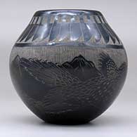 A black jar decorated with a sgraffito feather, roadrunner, serpent and nature design, click or tap to see a larger version