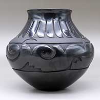 A black jar with a flared rim and decorated with a carved avanyu design separated from a carved feather design by a carved band of matte black geometric design, click or tap to see a larger version