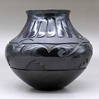 A black jar with a flared rim and decorated with a carved avanyu design separated from a carved feather design by a carved band of matte black geometric design, click or tap to see a larger version