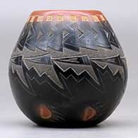 A small black jar with a sienna rim and spots, and decorated with a sgraffito knife-edge, bear paw and geometric design, click or tap to see a larger version