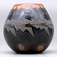 A small black jar with a sienna rim and spots, and decorated with a sgraffito knife-edge, bear paw and geometric design, click or tap to see a larger version
