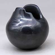 A small black jar with a geometric cut opening
 by Linda Askan of Santa Clara