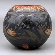 A black bowl with a sienna rim and spots, decorated with a sgraffito avanyu and geometric design with an inlaid stone, click or tap to see a larger version