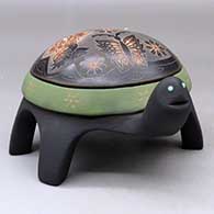 A polychrome turtle figure decorated with sienna spots, inlaid stones and a lightly carved and sgraffito hummingbird, flower, butterfly and geometric design
 by Melony Gutierrez of Santa Clara