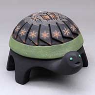 A polychrome turtle figure carved with a feather design and decorated on top with a sgraffito hummingbird, butterfly, flower and geometric design plus inlaid stones
 by Melony Gutierrez of Santa Clara