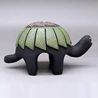 A polychrome turtle figure carved with a feather design and decorated on top with a sgraffito hummingbird, flower and geometric design plus inlaid stones, click or tap to see a larger version