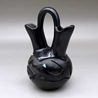 Click for a larger view A black with micaceous black wedding vase carved with a avanyu and geometric design plus an inlaid stone
by Melony Gutierrez of Santa Clara