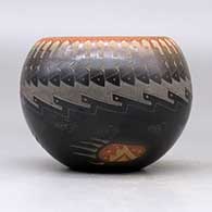 A black bowl with a sienna rim and spots decorated around the outside with a sgraffito knife edge, bear paw and geometric design, click or tap to see a larger version