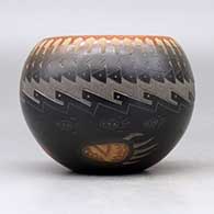 A black bowl with a sienna rim and spots decorated around the outside with a sgraffito knife edge, bear paw and geometric design, click or tap to see a larger version