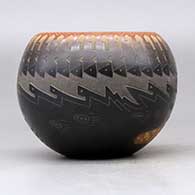 A black bowl with a sienna rim and spots decorated around the outside with a sgraffito knife edge, bear paw and geometric design, click or tap to see a larger version