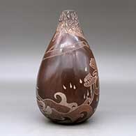 A brown jar with an organic opening, an applique fold and decorated with a sgraffito sea serpent, ocean wave and geometric design, click or tap to see a larger version