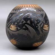 A black jar with a sienna rim and spots, decorated with a sgraffito avanyu, feather, bear paw and geometric design with an inlaid stone, click or tap to see a larger version