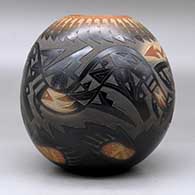 A black jar with a sienna rim and spots, decorated with a sgraffito avanyu, feather, bear paw and geometric design with an inlaid stone, click or tap to see a larger version