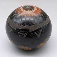 Click for a larger view A black seed pot with sienna spots, an inlaid stone and a sgraffito bear paw, feather and geometric design
by Justin Naranjo of Santa Clara