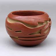 A red bowl decorated with a carved avanyu and geometric design around the body
 by Teresita Naranjo of Santa Clara