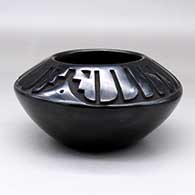 A black bowl carved with a ring of feather design above the shoulder
 by Chris Martinez of Santa Clara
