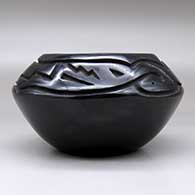 A black bowl carved above the shoulder with an avanyu and geometric design, click or tap to see a larger version