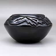 A black bowl carved above the shoulder with an avanyu and geometric design, click or tap to see a larger version