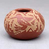 A small red jar decorated with a sgraffito hummingbird, butterfly and geometric design
 by Candelaria Suazo of Santa Clara