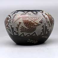 A black bowl decorated with sienna spots and a sgraffito hummingbird, butterfly and geometric design, click or tap to see a larger version