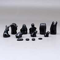 A thirteen piece miniature matte and polished black Nativity scene with Navajo wise men, click or tap to see a larger version