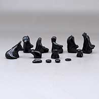 A thirteen piece miniature matte and polished black Nativity scene with Navajo wise men, click or tap to see a larger version