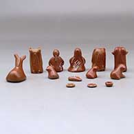 A thirteen piece miniature white on red Nativity scene with Navajo wise men, click or tap to see a larger version