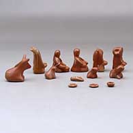 A thirteen piece miniature white on red Nativity scene with Navajo wise men, click or tap to see a larger version