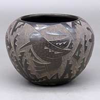 A black bowl decorated with a sgraffito rabbit, quail, hummingbird, butterfly sand geometric design
 by Candelaria Suazo of Santa Clara