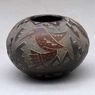 A small black jar with sienna spots and decorated with a sgraffito hummingbird, quail, butterfly and geometric design
 by Candelaria Suazo of Santa Clara