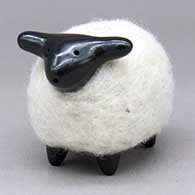 A highly polished black sheep figure in a coat of white wool
 by Joe and Eunice Naranjo of Santa Clara