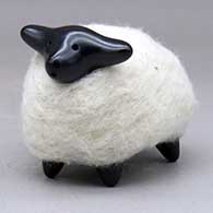 A highly polished black sheep figure wearing a coat of white wool
 by Joe and Eunice Naranjo of Santa Clara