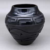 A black jar carved with an avanyu and geometric design around and above the shoulder
 by Sherry Tafoya of Santa Clara