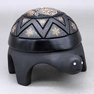 A polychrome turtle figure with sienna spots and decorated with a carved and sgraffito feather, flower, butterfly and geometric design, plus five inlaid stones
 by Melony Gutierrez of Santa Clara