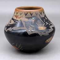 A black jar with sienna spots and rim, decorated with a sgraffito avanyu, bear paw and geometric design plus an inlaid stone
 by Sammy Naranjo of Santa Clara
