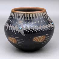 A black jar with sienna spots and rim, decorated with a sgraffito feather, bear paw and geometric design plus four inlaid stones
 by Sammy Naranjo of Santa Clara