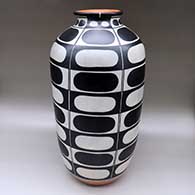 A tall polychrome cylinder with a rolled lip and decorated with a geometric design
 by Thomas Tenorio of Santo Domingo