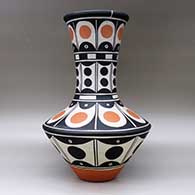 A tall polychrome jar with a recurved neck, decorated with bands of geometric design around the body, click or tap to see a larger version