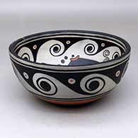 A polychrome bowl decorated with a fish and geometric design inside, and with a spiral and geometric design outside, click or tap to see a larger version