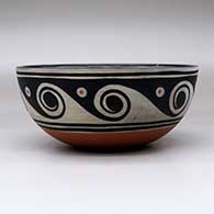 A polychrome bowl decorated with a fish and geometric design inside, and with a spiral and geometric design outside, click or tap to see a larger version