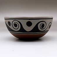 A polychrome chili bowl decorated with a fish and water symbol design inside, and a water symbol design outside, click or tap to see a larger version