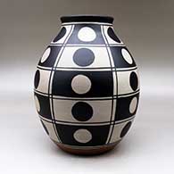 A polychrome jar decorated with a black and white geometric design, click or tap to see a larger version