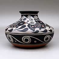 A low shouldered polychrome jar with a flared rim and decorated with a four panel fish, spiral and geometric design, click or tap to see a larger version