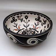 A large, deep polychrome bowl decorated inside with fish, birds, plants  and geometric design, and outside with spirals and water symbols, click or tap to see a larger version