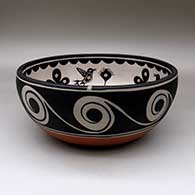 A large, deep polychrome bowl decorated inside with fish, birds, plants  and geometric design, and outside with spirals and water symbols, click or tap to see a larger version