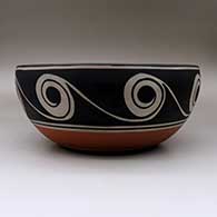 A large, deep polychrome bowl decorated inside with fish, birds, plants  and geometric design, and outside with spirals and water symbols, click or tap to see a larger version