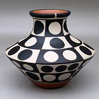 A low, wide-shouldered polychrome jar with a recurved neck and decorated with a six panel geometric design
 by Thomas Tenorio of Santo Domingo