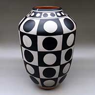 A tall jar decorated with a dot and checkerboard geometric design
 by Thomas Tenorio of Santo Domingo