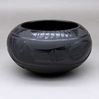 A black-on-black bowl decorated with an avanyu, feather, rain cloud and geometric design
 by Marvin and Frances Martinez of San Ildefonso